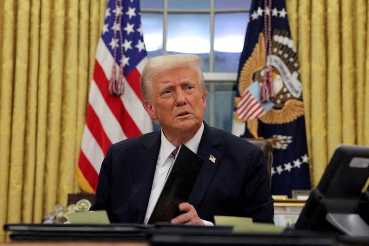 Reuters/Carlos Barria/Proibida reprodução FILE PHOTO: U.S. President Donald Trump signs documents as he issues executive orders and pardons in the Oval Office at the White House on Inauguration Day in Washington, U.S., January 20, 2025. Reuters/Carlos Barria/Proibida reprodução