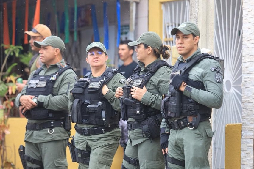 Policiais Militares e Guardas Municipais fazem o patrulhamento preventivo em meio à multidão no Carnaval do Jura 2026 em Gravatá. A imagem destaca a presença ostensiva das forças de segurança para garantir a tranquilidade dos foliões no bairro do Jucá.