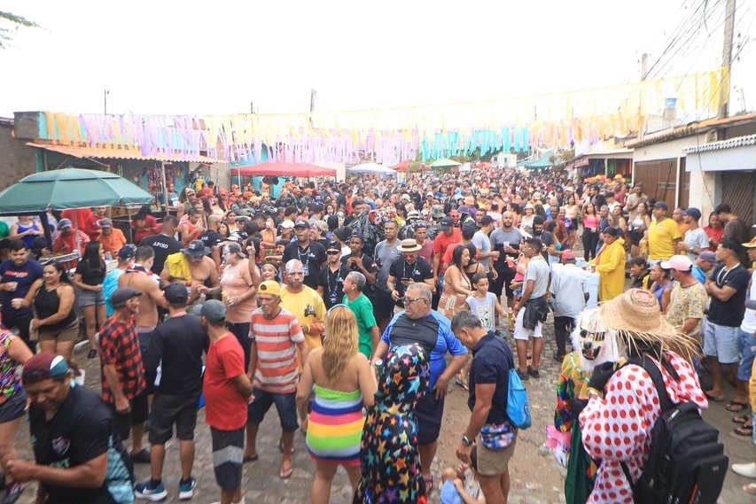 Público animado dançando ao som de swingueira em frente ao palco principal do Carnaval do Jura 2026, no bairro do Jucá, em Gravatá. A foto destaca a proximidade das bandas com a multidão e a organização da estrutura montada na rua.