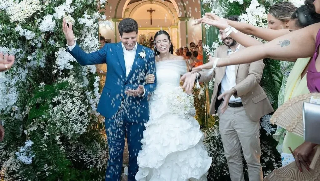 Foto do casamento de João Campos e Tabata Amaral na Praia dos Carneiros. O casal aparece em momento de celebração ao ar livre, em cerimônia que reuniu lideranças como Geraldo Alckmin e Alexandre de Moraes.