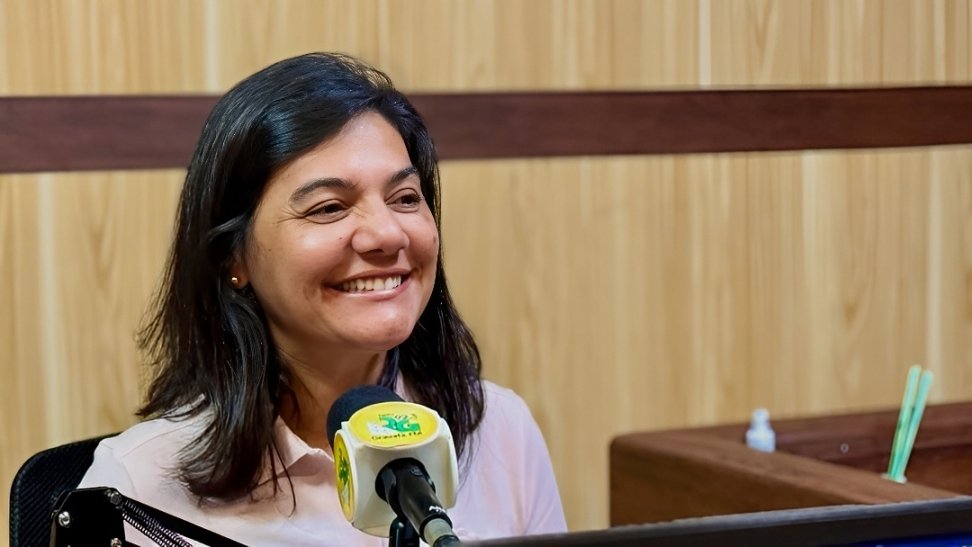 Viviane Facundes sorridente durante entrevista ao programa Primeira Página, na Rádio Gravatá FM