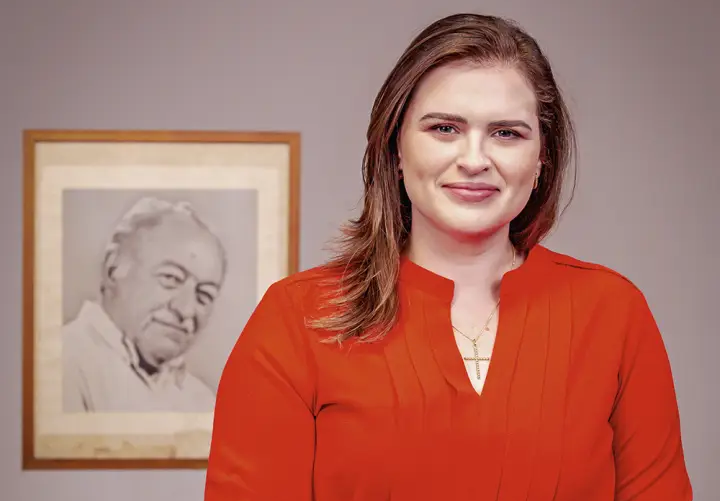 Marília Arraes em retrato oficial com imagem de Miguel Arraes ao fundo em Pernambuco