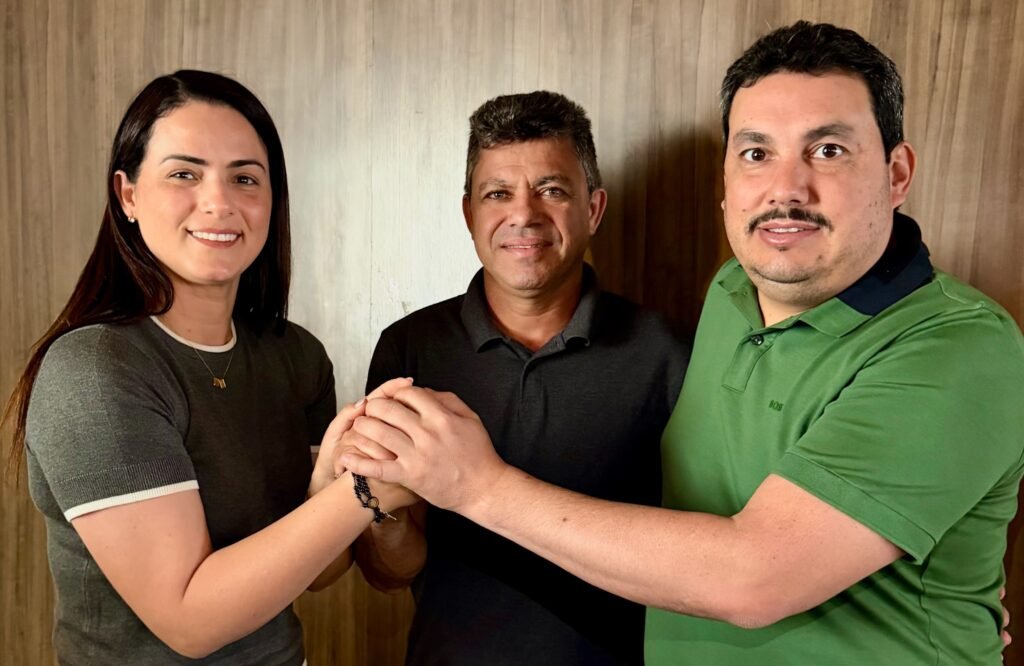 Juliana Chaparral, o vereador Ademir Batista ao centro e Cleber Chaparral unidos de mãos dadas selando apoio político em Chã Grande.