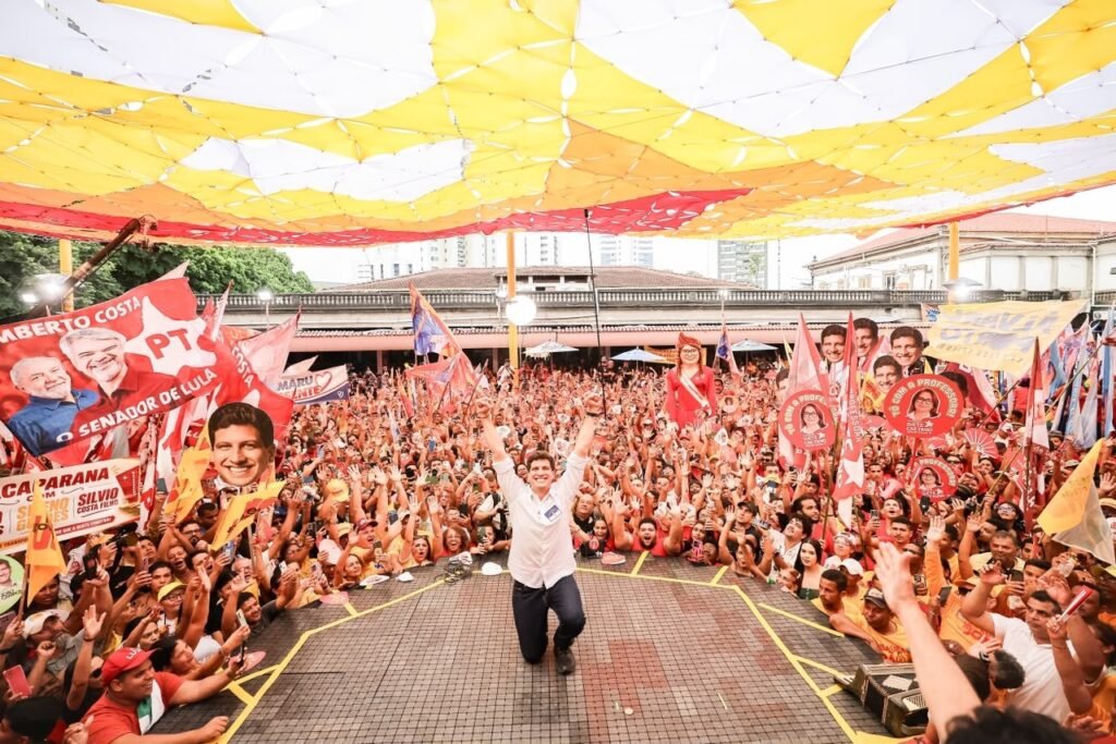 João Campos em ato de campanha durante convenção do PSB no Recife com multidão de apoiadores e bandeiras políticas