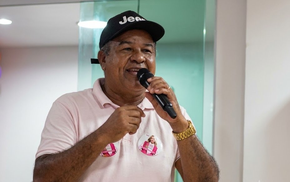 O ex-vereador José Romildo, o Nego Suíno, discursa com microfone e adesivo de campanha no peito durante ato político em Gravatá.