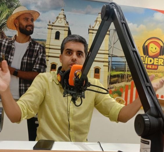 Renan Hallais, candidato ao Governo de Pernambuco pelo partido Missão, concedendo entrevista com os braços abertos no estúdio da Rádio Líder FM.