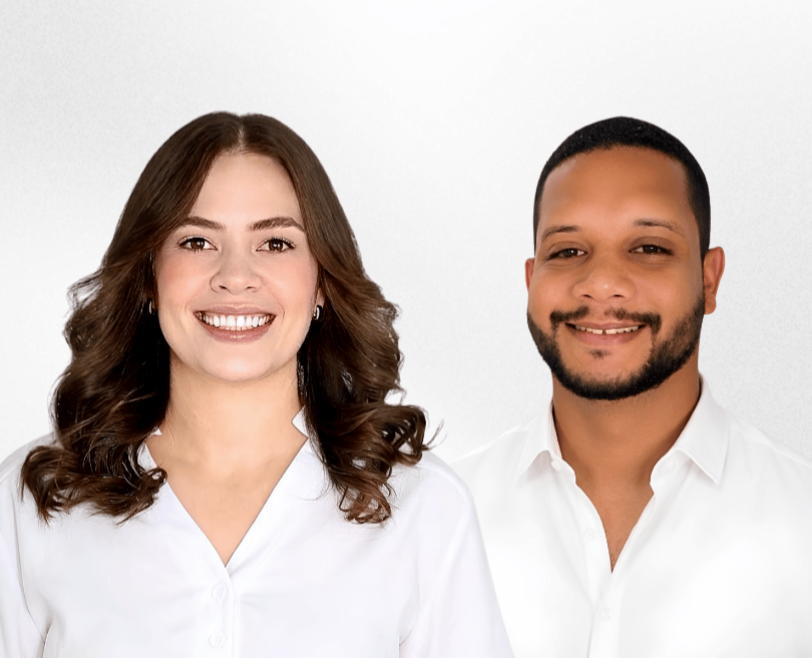 Cássio Machado e Helloysa Ferreira sorriem lado a lado vestindo camisas brancas em estúdio sobre fundo claro.