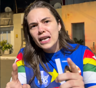 Mulher em primeiro plano durante declaração sobre segurança pública e violência contra a mulher em Pernambuco