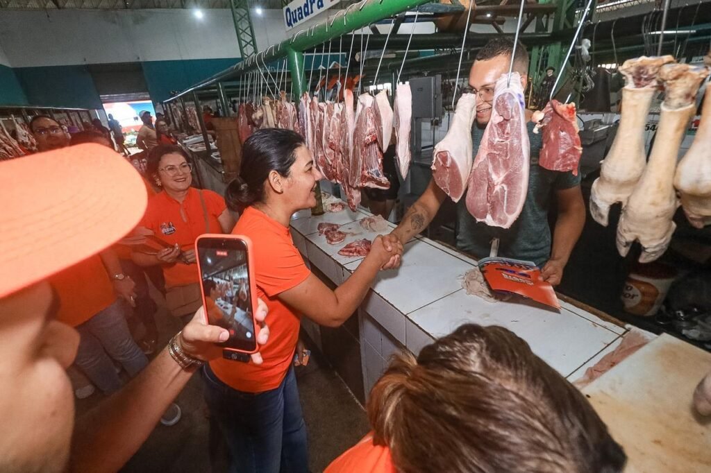 Viviane Facundes cumprimenta um comerciante com um aperto de mão em um açougue no mercado público de Bezerros.