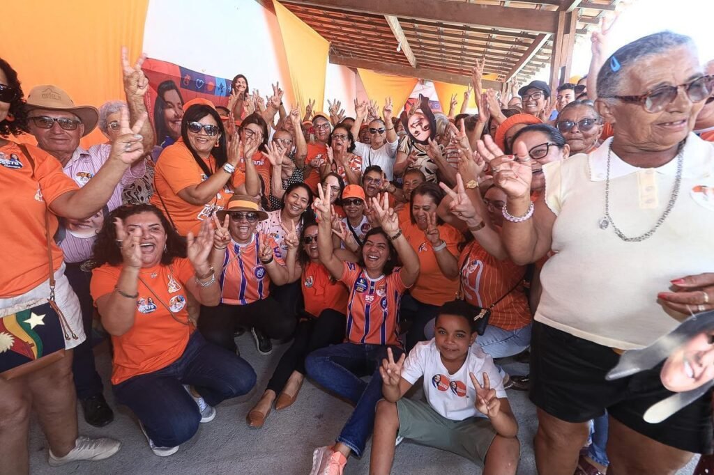 Viviane Facundes e um grupo animado de idosos fazem o sinal de vitória com as mãos durante café da manhã em Gravatá.