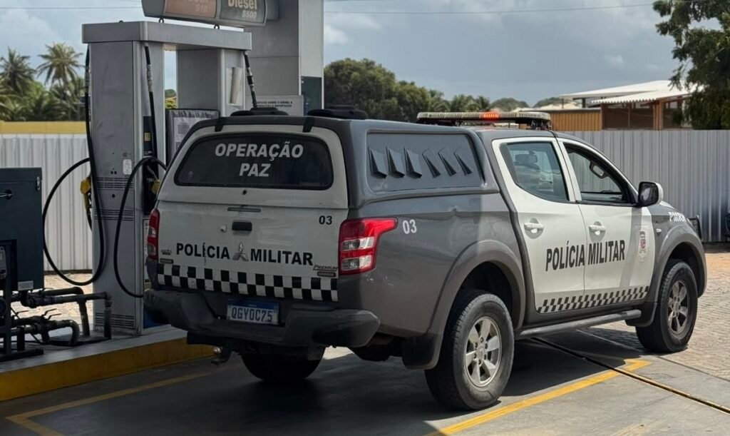 Viatura da Polícia Militar do Rio Grande do Norte (PMRN) estacionada ao lado de uma bomba em um posto de combustível.