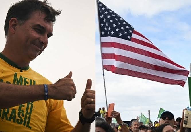 Flávio Bolsonaro com camisa amarela do Brasil ao lado de uma bandeira dos Estados Unidos em meio a uma multidão.