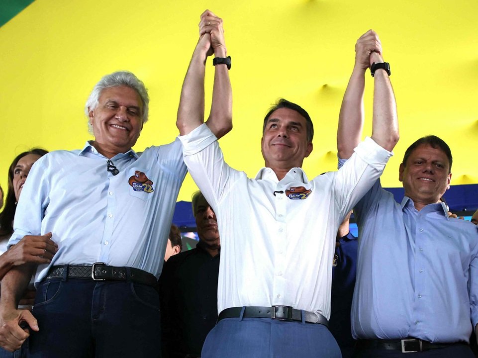 Ronaldo Caiado e Flávio Bolsonaro levantam as mãos durante ato de apoio ao segundo turno em Goiânia