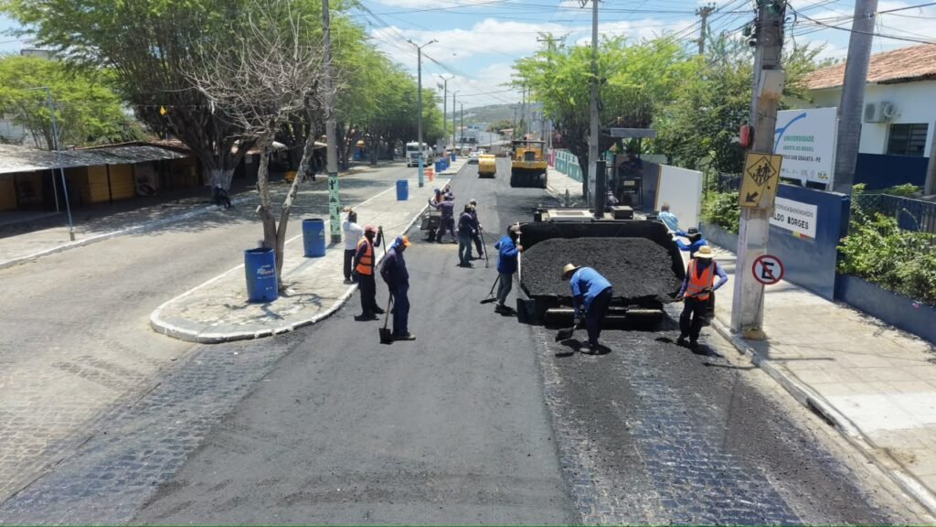 Trabalhadores executam capeamento asfáltico na Avenida Joaquim Didier, próximo à EREM Devaldo Borges, em Gravatá (PE).