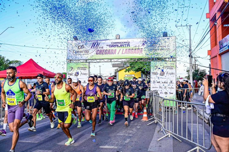 Corredores de rua largam em prova comemorativa de 10 anos do grupo Corredores de Gravatá. Atletas correm sob uma chuva de confetes azuis na pórtico de largada e chegada.