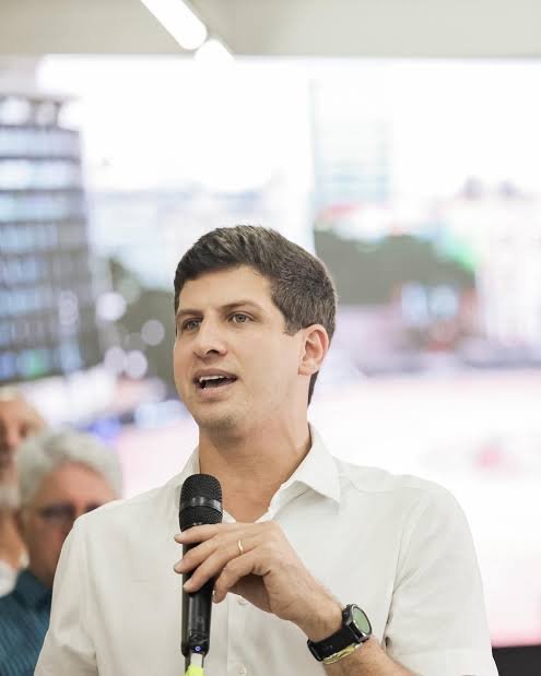 João Campos (PSB), ex-prefeito do Recife e candidato ao governo de Pernambuco em 2026, segura um microfone durante pronunciamento, marcando sua primeira derrota eleitoral após histórico de vitórias.