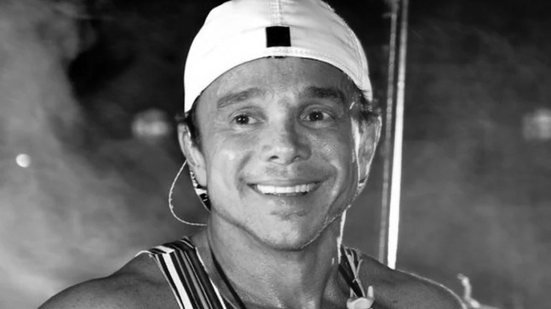 Cantor Netinho, intérprete de “Milla”, aparece sorrindo em fotografia em preto e branco.