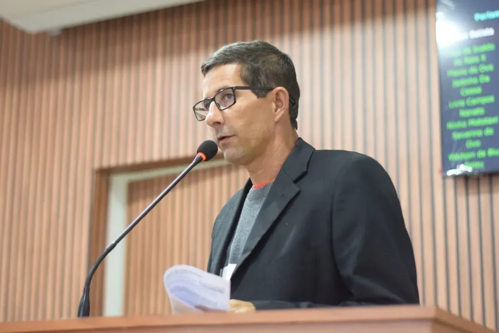 O vereador Ninho Mototáxi discursando no púlpito da Câmara Municipal de Chã Grande usando paletó escuro e óculos de grau.