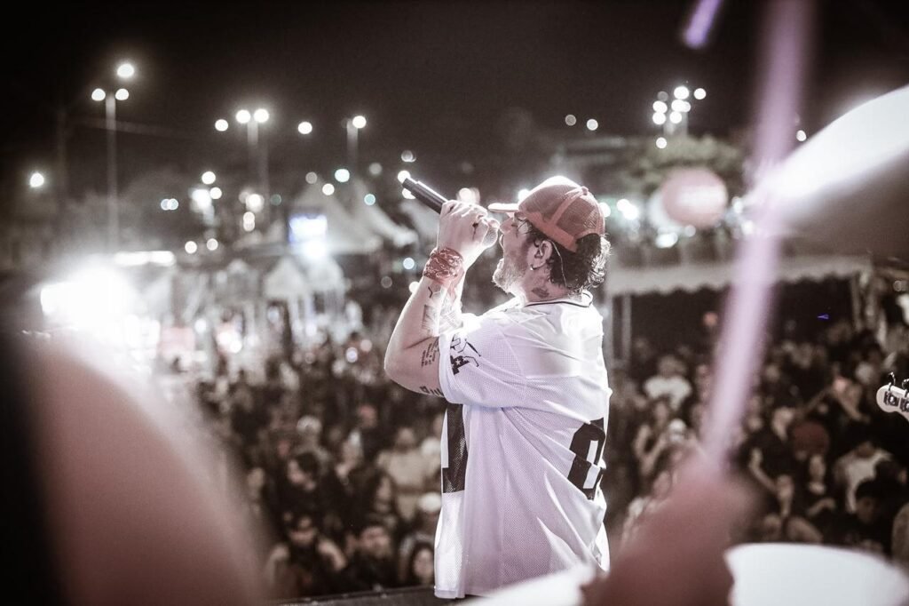 O cantor Bob Tayson se apresenta no palco durante o 5º Gravatá Motofest, em Gravatá, diante de uma multidão à noite.