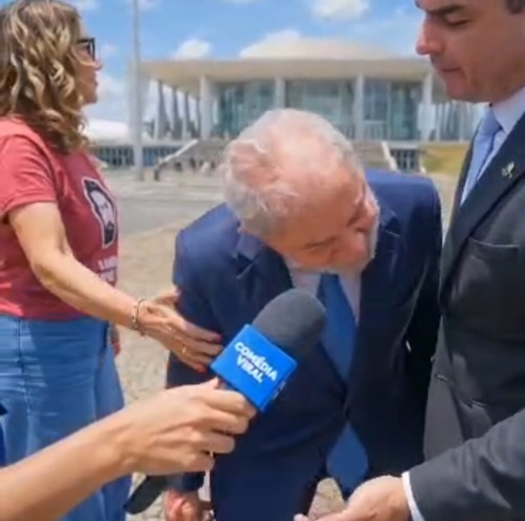[Lula, Janja e Flávio Bolsonaro em discussão simulada por inteligência artificial em frente ao Palácio do Planalto, com microfone da Comédia Viral](Video-criado-por-IA-coloca-Lula-e-Flavio-Bolsonaro-en-versao-politica-do-meme-arreia-a-mao-na-minha-cara-)
